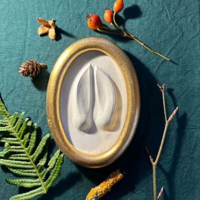 Gipsabguss einer Hirschspur gerahmt in einem Goldrahmen aus Holz