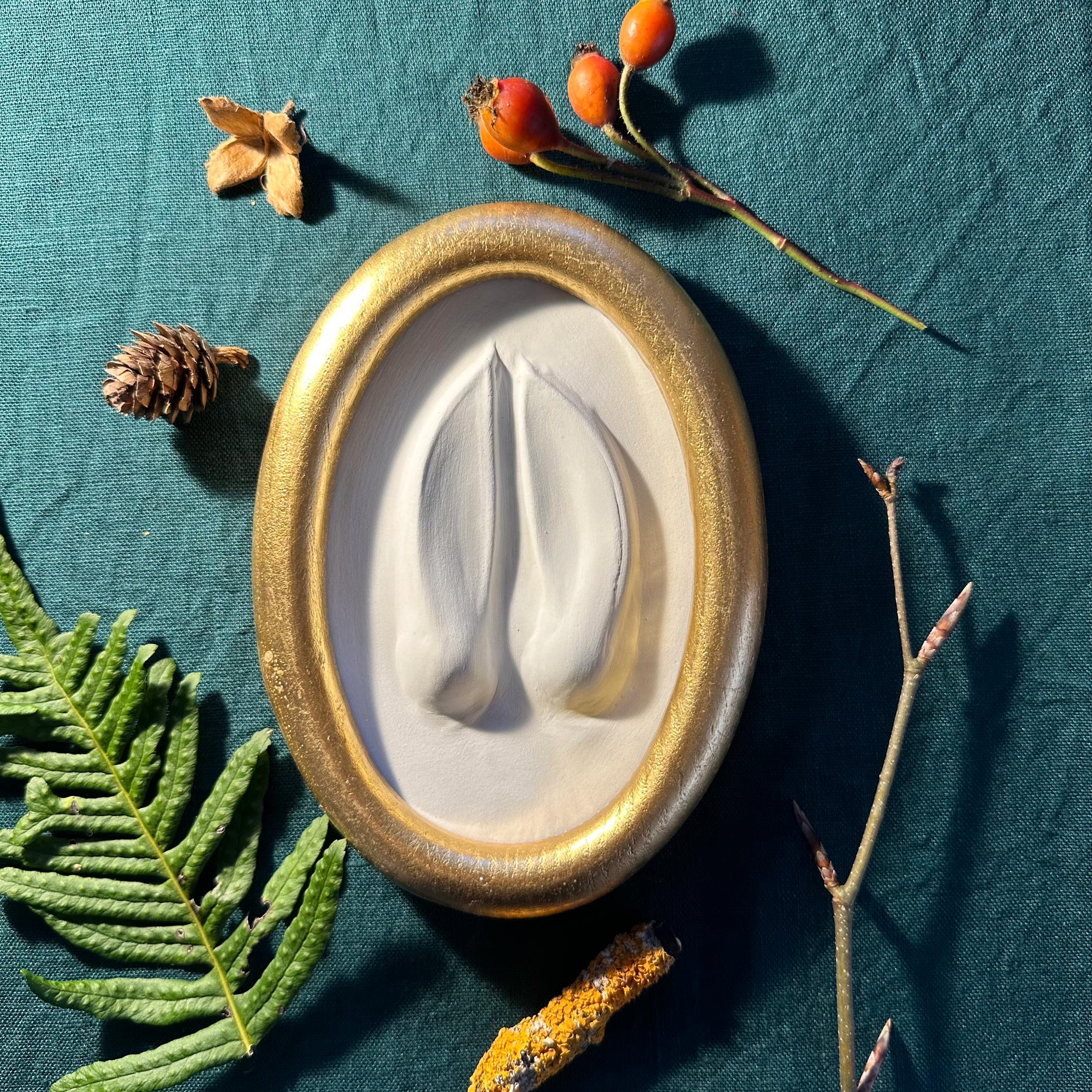 Gipsabguss einer Hirschspur gerahmt in einem Goldrahmen aus Holz