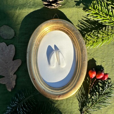 Gipsabguss einer Rehspur gerahmt in einem ovalen Goldrahmen aus Holz